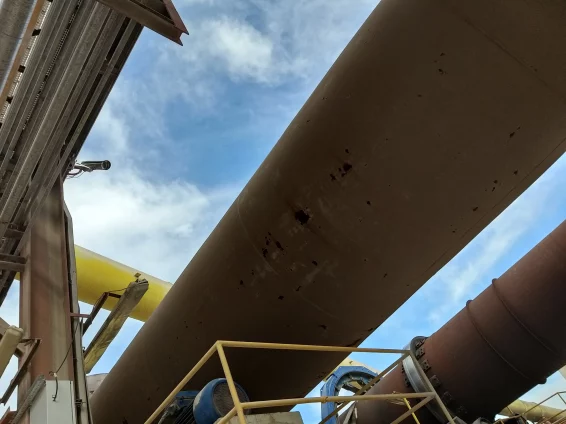 Vista inferior de un horno rotativo en planta industrial